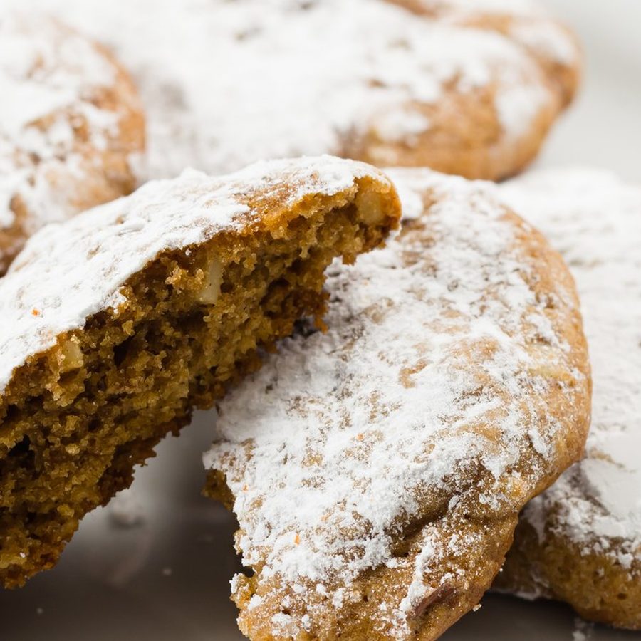 Pfeffernüsse dusted with powdered sugar, one broken open